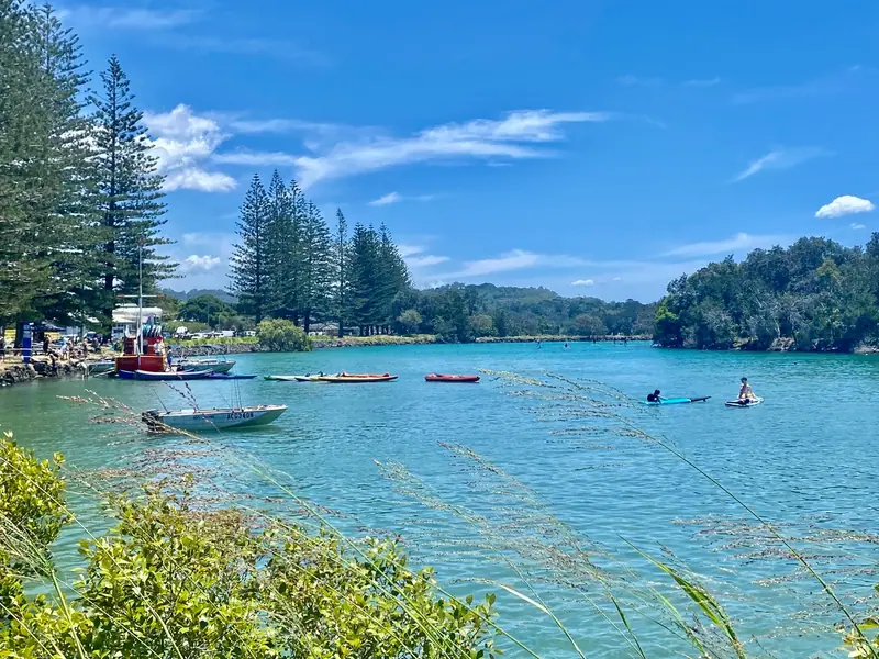 Kayaks and paddleboarders on the turquoise Brunswick River on a sunny day